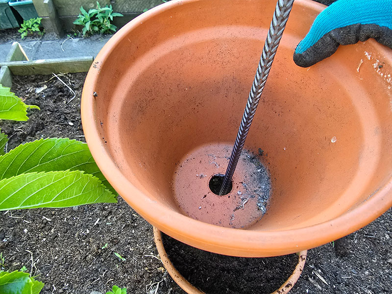 terracotta plantenpotten stapelen over betonijzer in de grond, de tweede stap van je eigen kruidentoren maken