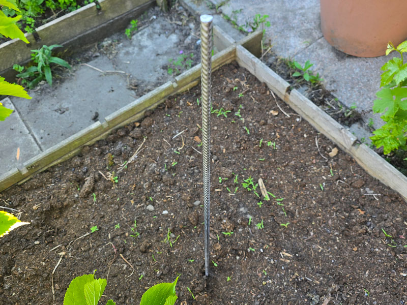betonijzer voor terracotta kruidentoren in een moestuinbak in de grond geslagen, een ijzeren ondersteuning voor jouw plantentoren maken